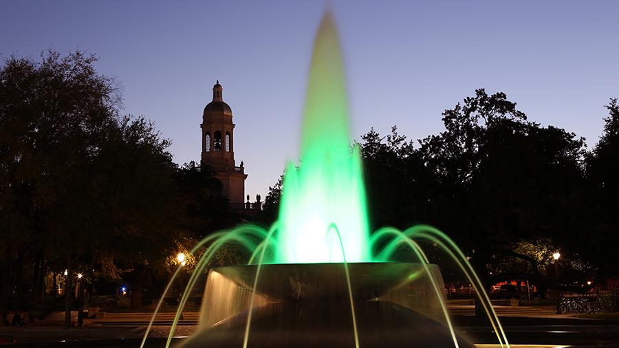 Baylor Fountain at night, lit by green light.